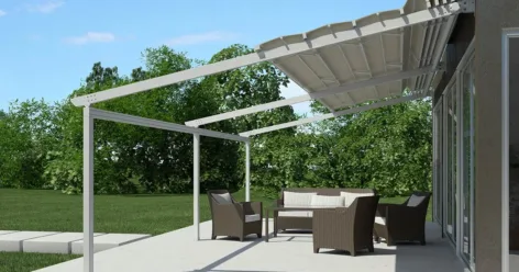 Faltbare Pergola von Metaform.gr mit Textildach, installiert im Garten eines Wohnhauses für flexible Beschattung.