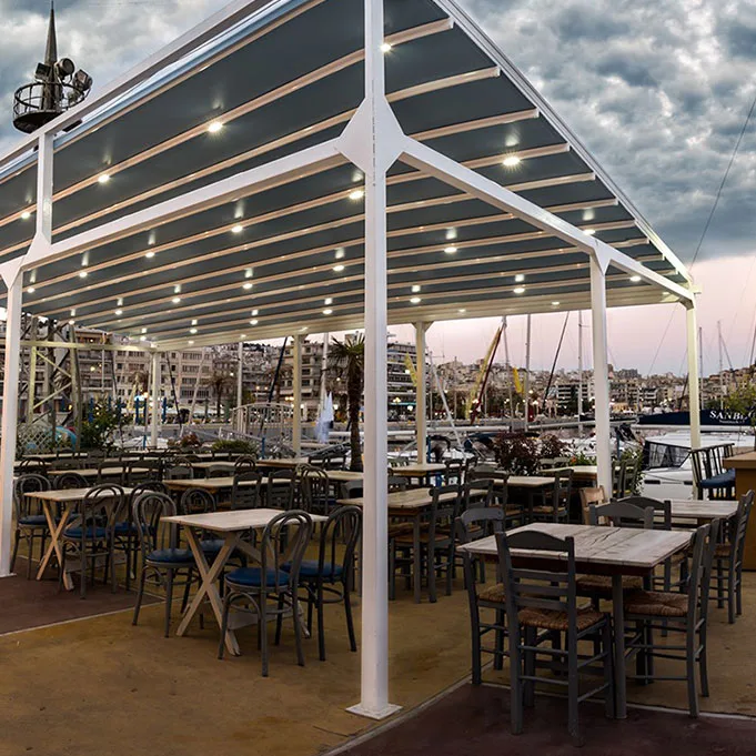 Μοντέρνα πέργκολα σε rooftop εστιατόριο με κρεμαστή διακόσμηση και θέα σε πολυκατοικίες